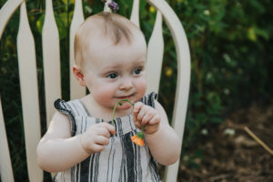 Tot tries to eat a flower during a first birthday celebration in Hillsboro, Oregon.