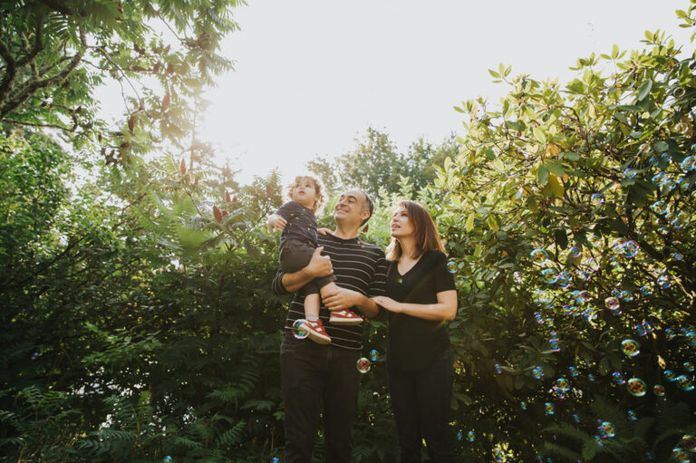 Parents and child point to an airplane in their Portland backyard during a lifestyle family photography session.