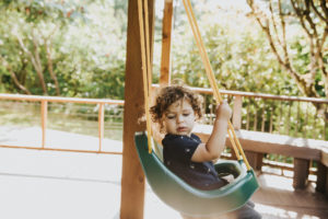 Little kid swings in their Portland Oregon backyard during a lifestyle family photography session with meg ross photography