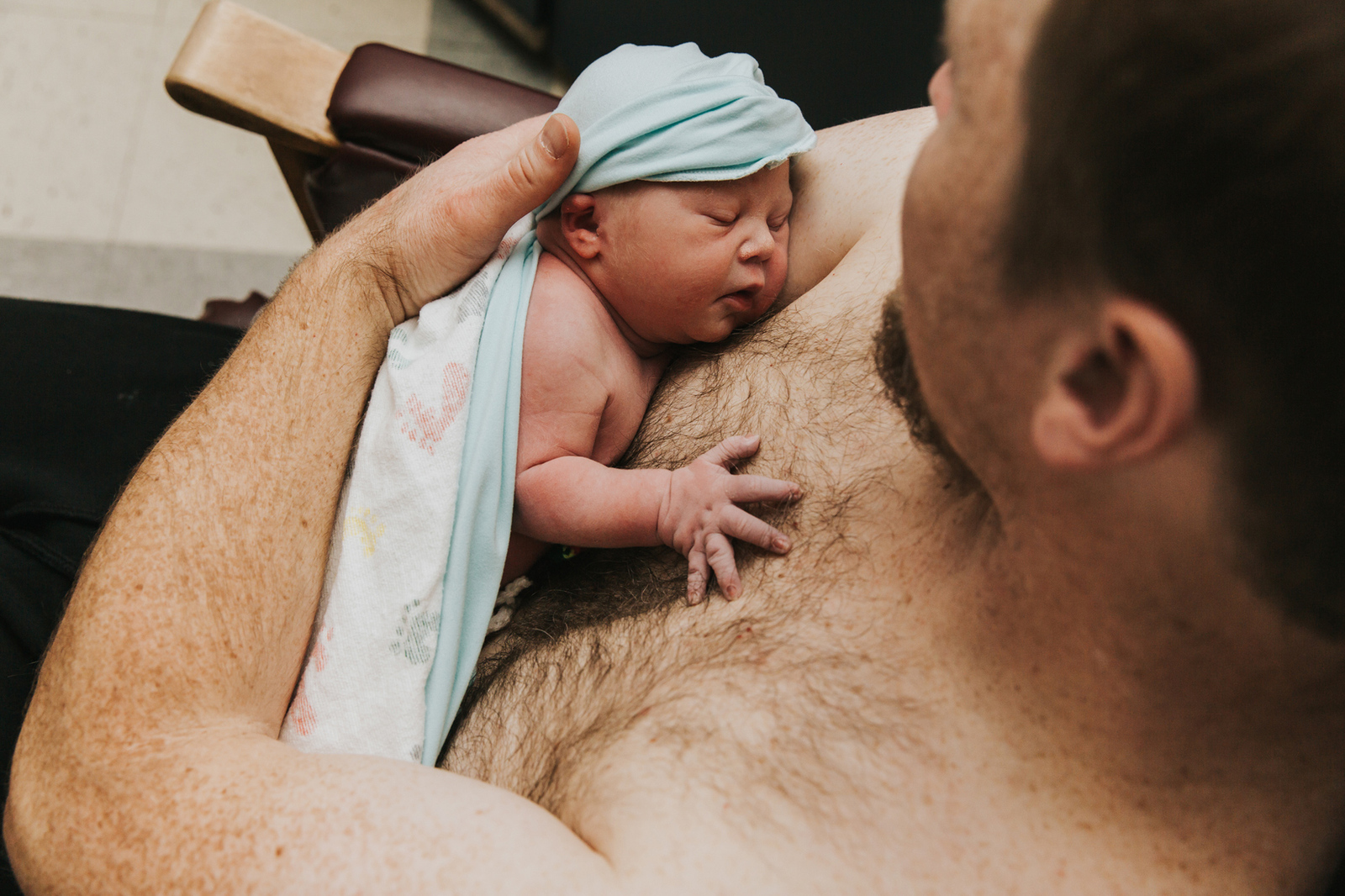 Newborn baby on dad's bare chest