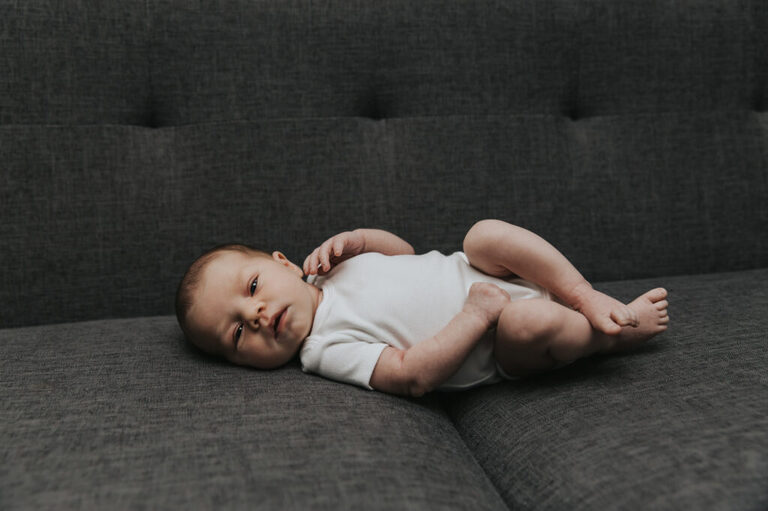 Portland Newborn Photographer, baby laying on a couch at a lifestyle newborn session in Oregon.