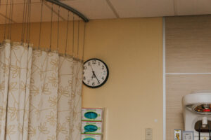 Hospital room clock slightly hidden by a curtain shows delivery time of a baby to be 6:25 AM at Kaiser Westside in Hillsboro Oregon