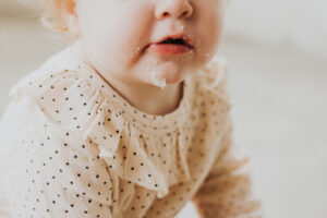 Close up on a white toddler's chin with donut glaze messy and everywhere